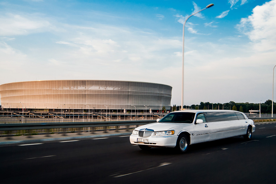 Długa biała luksusowa limuzyna na tle stadionu we Wrocławiu
